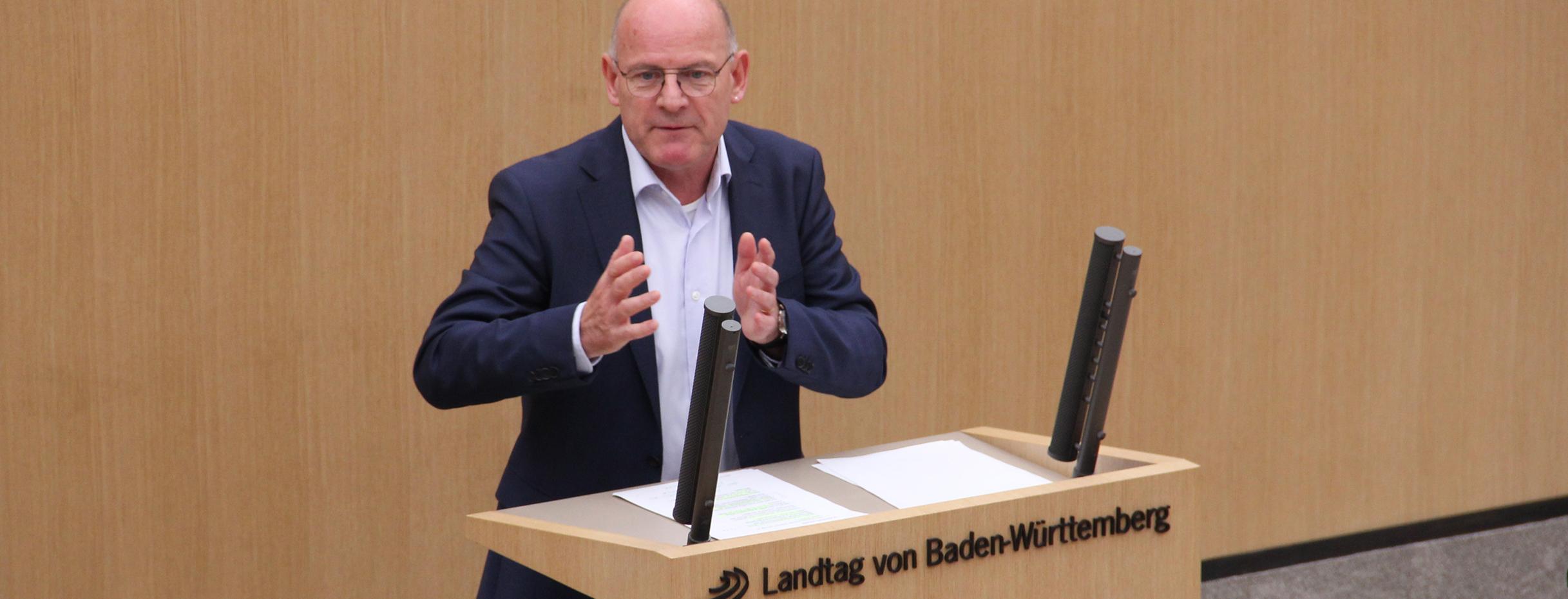 Minister Winfried Hermann steht hinter dem Rednerpult im Landtag von Baden-Württemberg und spricht zu den Abgeordneten (11.01.2017)