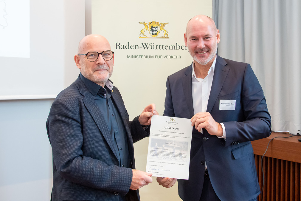 Winfried Hermann überreicht die Urkunde an Oberbürgermeister Martin Georg Cohn der Stadt Leonberg