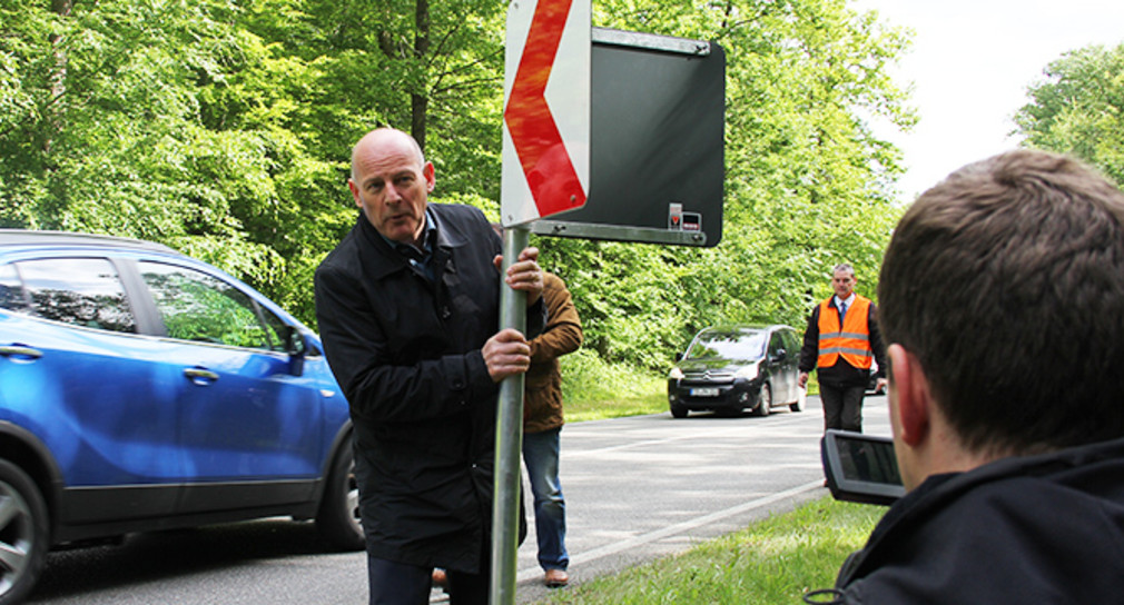 Verkehrsminister Hermann mit einer scharfkantigen Tafel aus Blech und Stahlrohr, die durch die neuen Leittafeln ersetzt wird.