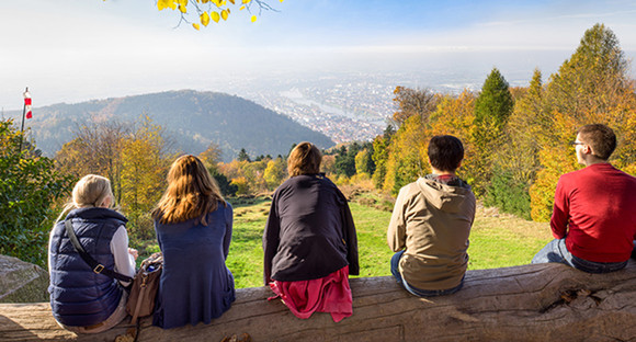 Mehrere Menschen blicken vom Königstuhl auf Heidelberg und die Rheinebene (Bild: Fotolia.com)