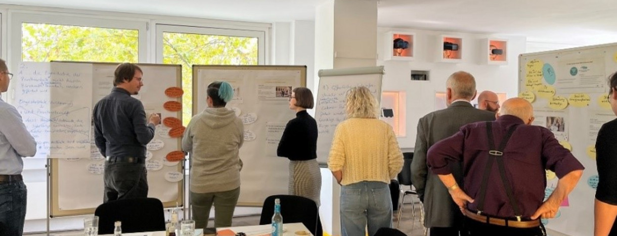 Bürgerinnen und Bürger kommen in Stuttgart miteinander ins Gespräch: Menschen informieren sich an Pinnwänden und diskutieren über die Inhalte