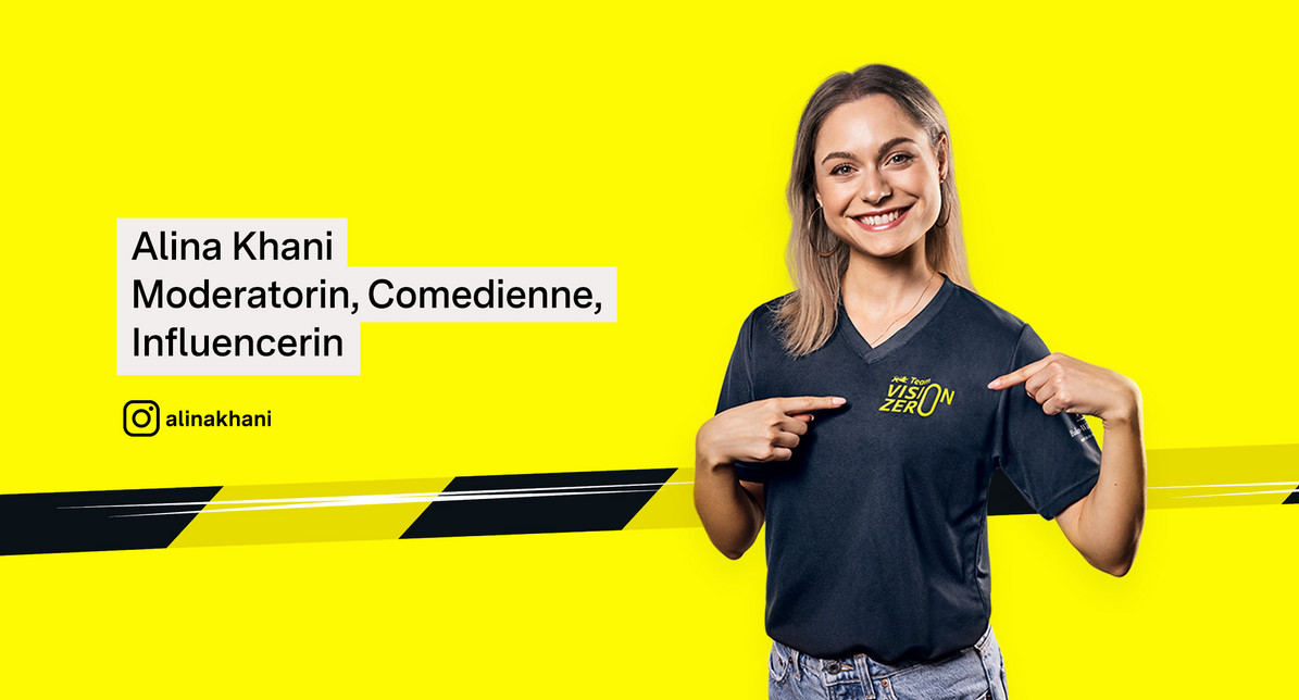 Porträtfoto von Alina Khani. Sie trägt ein Team Vision Zero-Shirt und zeigt mit beiden Fingern auf das Logo auf der Brust.