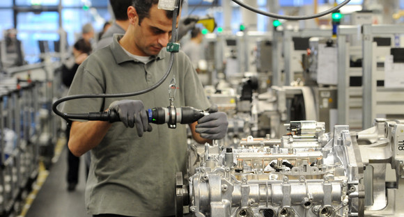 Ein Mitarbeiter baut einen Motor zusammen in einer Fabrik (Bilderquelle: dpa/30967213)