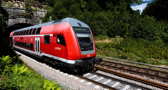 Ein Doppelstockzug fährt aus einem Tunnel heraus.
