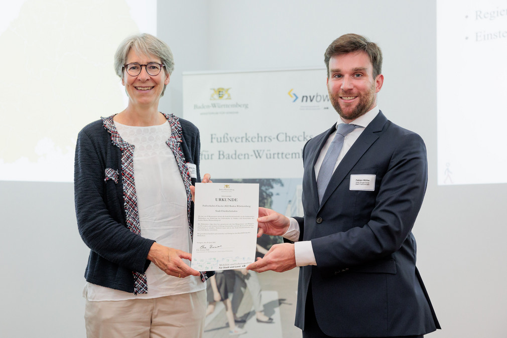 Staatssekretärin Elke Zimmer überreicht Fabian Müller, erster Bürgermeister der Stadt Friedrichshafen, eine Urkunde für die Teilnahme an den Fußverkehrs-Checks 2022.