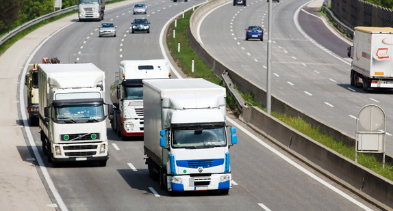 Auf einer Autobahn fahren Lastwagen und Autos nebeneinander (Bild: Fotolia.com/ Gina Sanders)