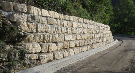 Stützmauer aus großen Steinen an einem Straßenrand
