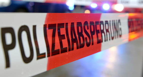 Ein Flatterband mit der Aufschrift Polizeiabsperrung ist in Freiburg an einem Einsatzort vor einem Feuerwehrfahrzeug mit Blaulicht zu sehen.  Ein Fußgänger ist am 16.06.2017 bei einem illegalen Autorennen in Mönchengladbach getötet worden. Bild: Patrick Seeger/dpa