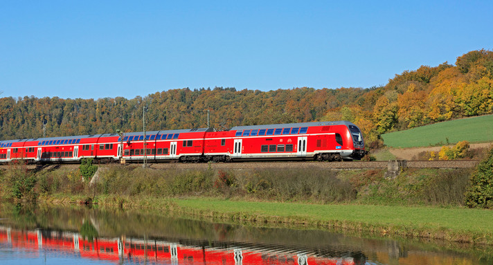 Netz 20 Main-Neckar-Ried Ein roter Zug der Deutschen Bahn fährt an einem Fluss entlang.