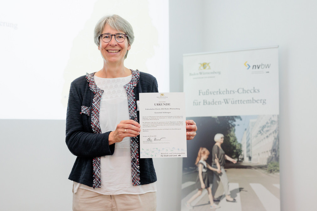 Staatssekretärin Elke Zimmer zeigt die Urkunde der Gemeinde Schliengen für die Teilnahme an den Fußverkehrschecks 2022.