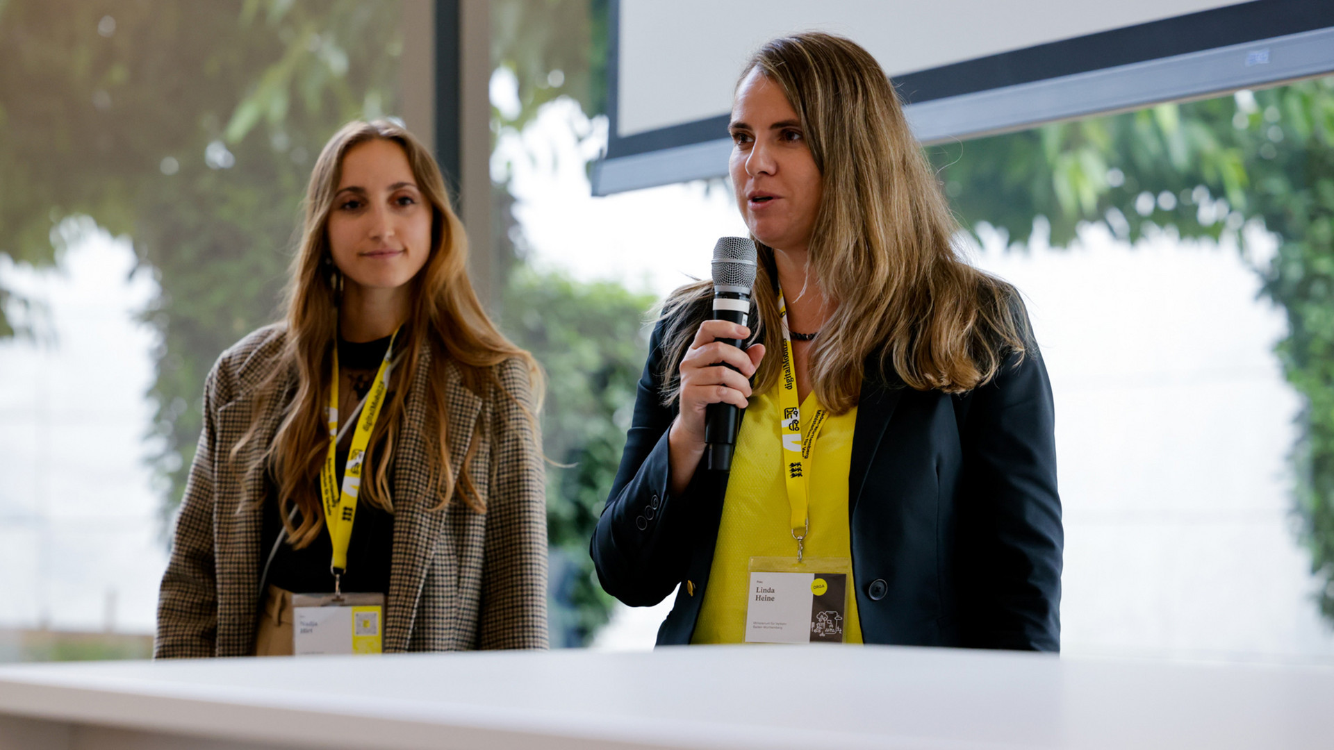 Eine Frau steht auf einer Bühne und hält einen Vortrag.