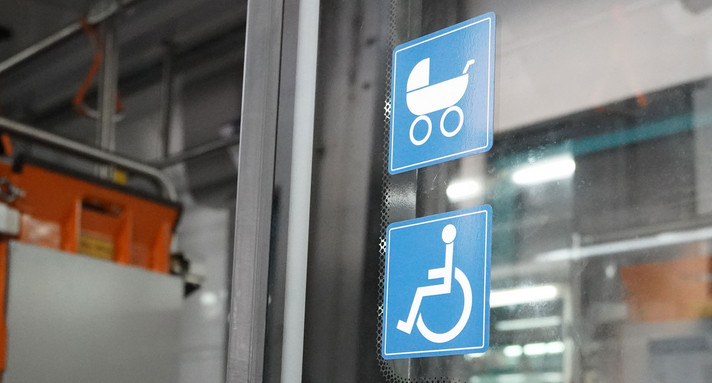 Türe einer Straßenbahn mit Aufklebern für Rollstuhl und Kinderwagen.