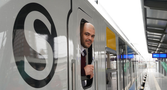 Ein Mann schaut aus dem Führerstand eines Zuges auf den Bahnsteig.