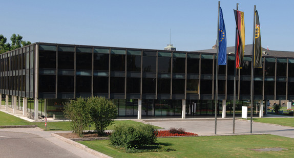 Gebäude des Landtags von Baden-Württemberg mit davor wehenden Flaggen von Deutschland, Baden-Württemberg und der Europäischen Union.