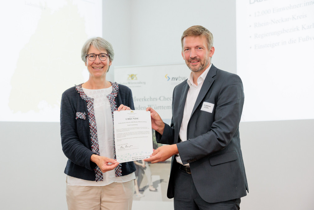 Staatssekretärin Elke Zimmer überreicht Stefan Schmutz, Bürgermeister von Ladenburg, eine Urkunde für die Teilnahme an den Fußverkehrs-Checks 2022.