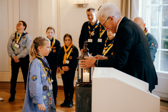 Ministerpräsident Winfried Kretschmann (rechts) mit Pfadfinderinnen und Pfadfindern bei der Übergabe des Friedenslichts