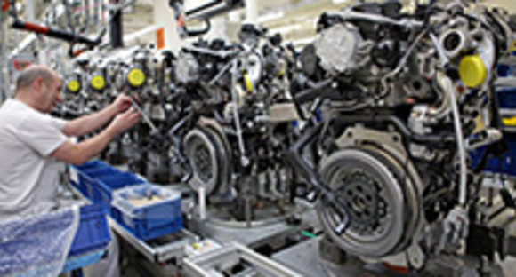 Ein Mitarbeiter von Volkswagen montiert am Fließband einen Dieselmotor. (Bilderquelle: dpa)