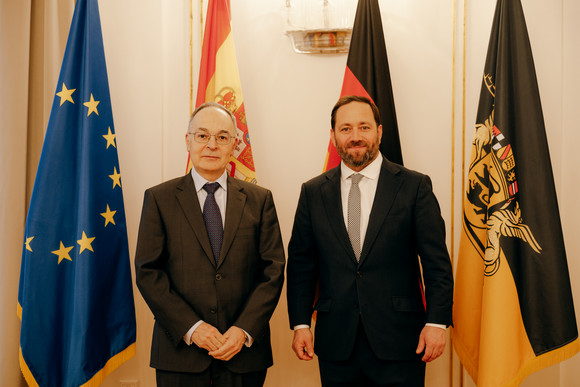 Antrittsbesuch Kretschmann empfängt spanischen Botschafter Staatssekretär Florian Hassler (rechts) und der spanische Botschafter Pascual Ignacio Navarro Rios (links) stehen vor Fahnen.