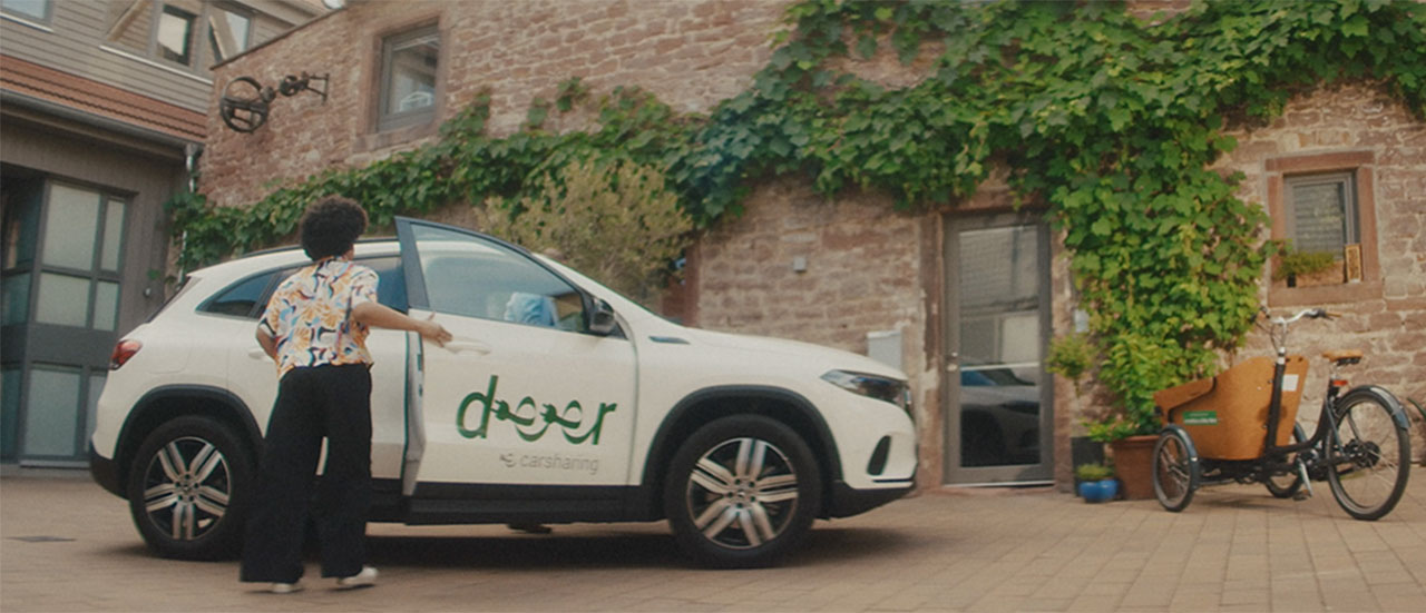 Ein Carsharing-Auto steht vor einem Hauseingang.